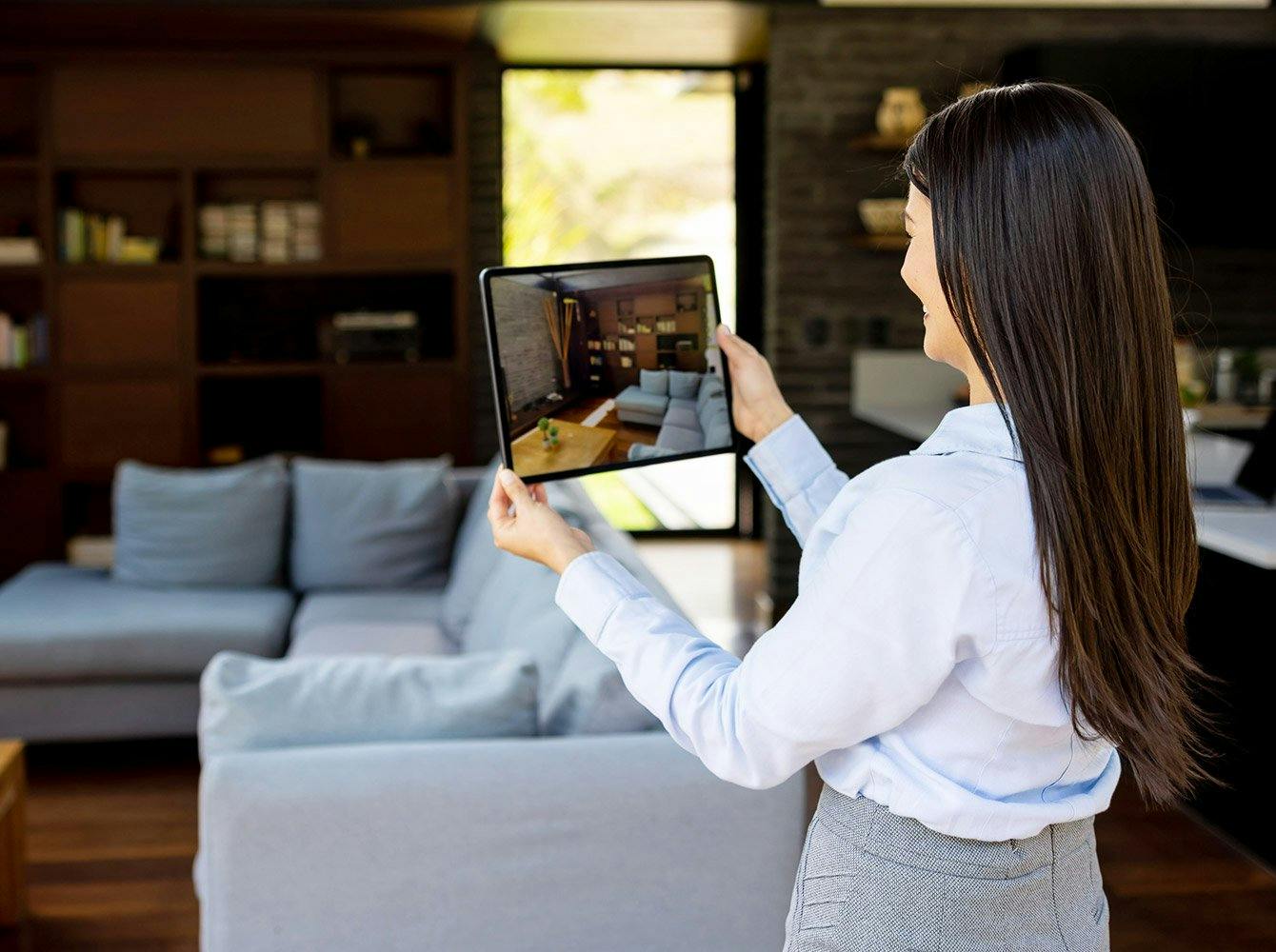 woman taking a picture of a living room on a tablet