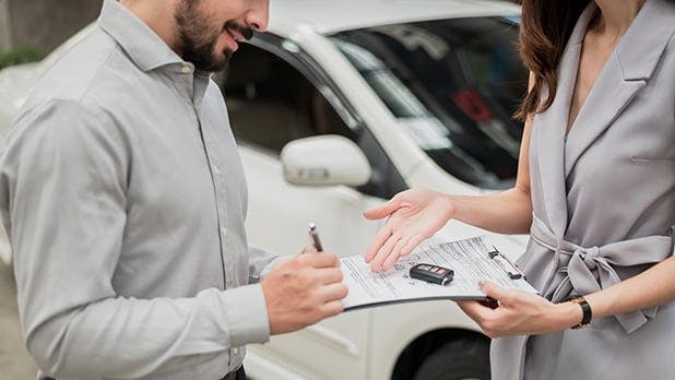 Person filling out paperwork to rent a car