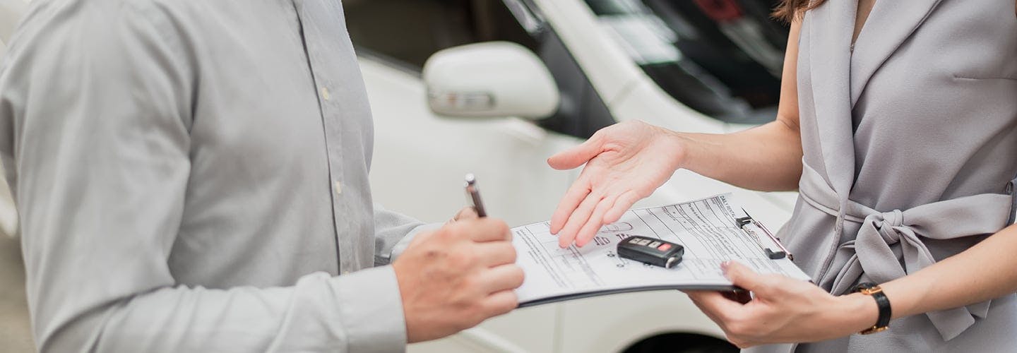 Person filling out paperwork to rent a car