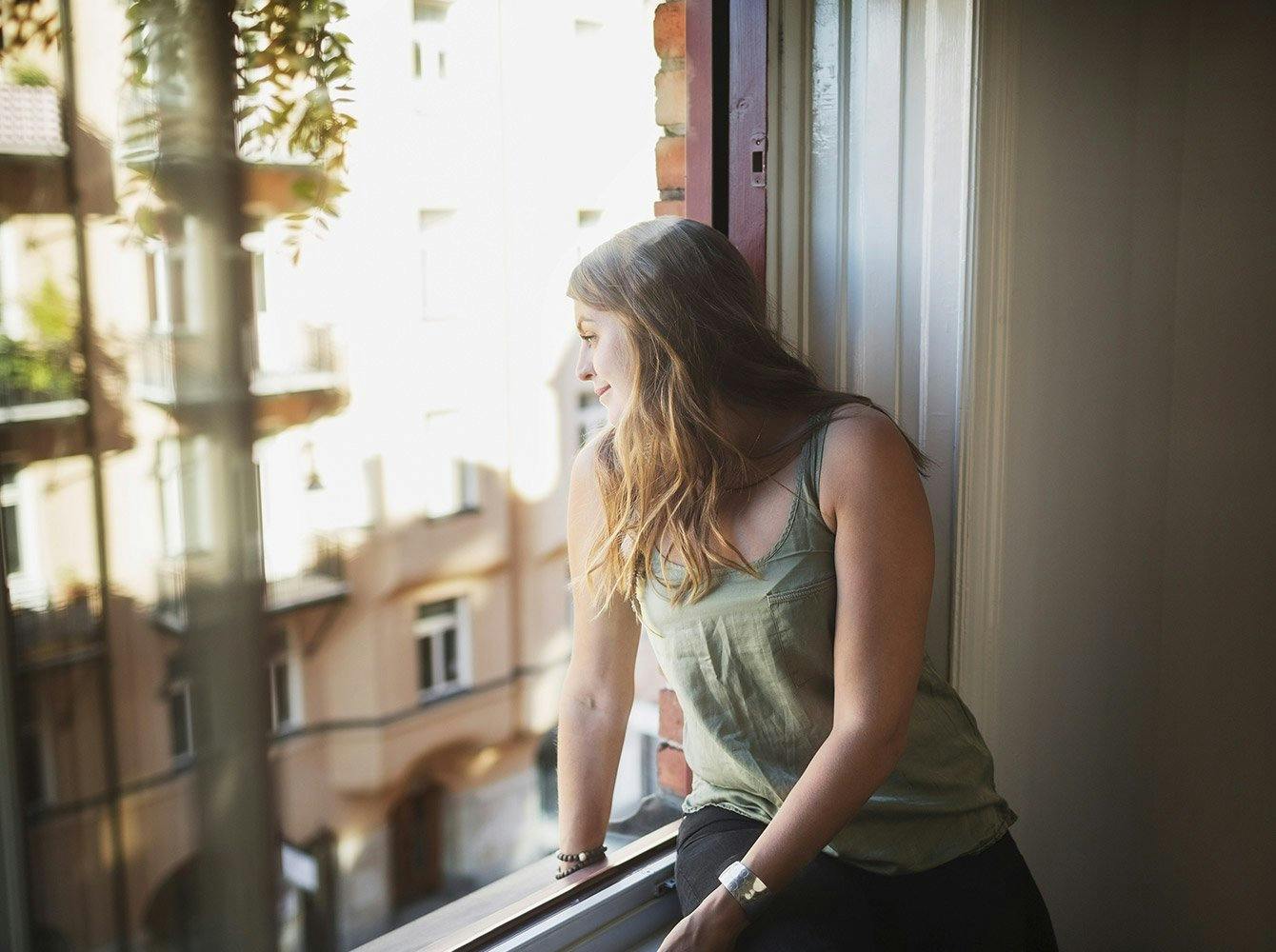 woman looking out the window in an apartment